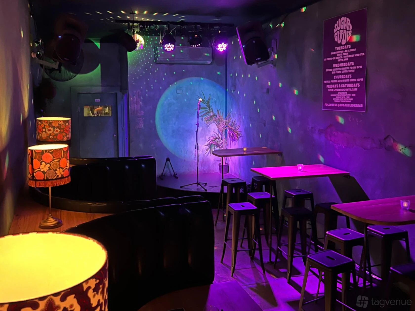 Sugar Glider’s main room with stage, booth seating and purple lighting